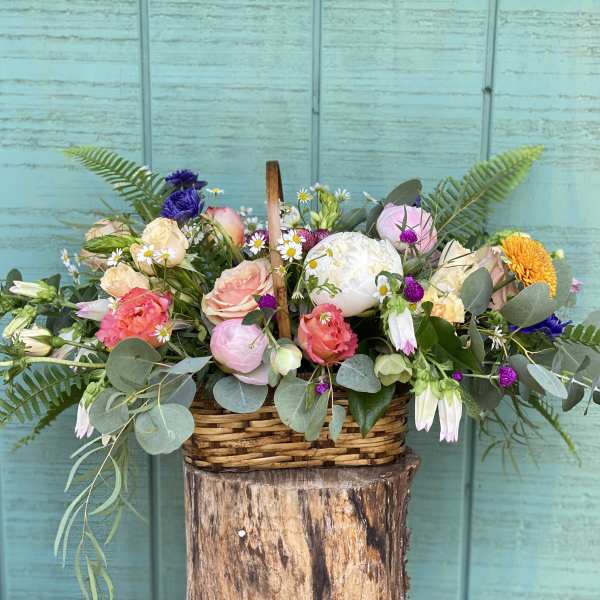 Mixed pastel flower arrangement in a wicker basket
