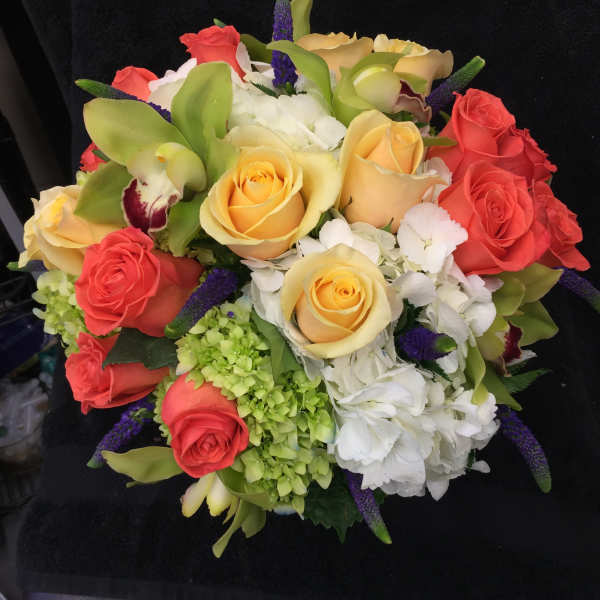 Bouquet of coral and yellow roses with white hydrangeas and purple accents
