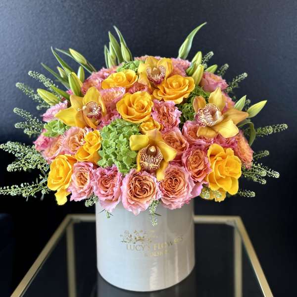 Pink and yellow rose bouquet in a white hat box with orchids