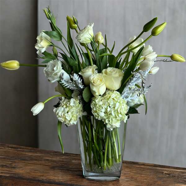 White roses and hydrangeas in a clear glass vase