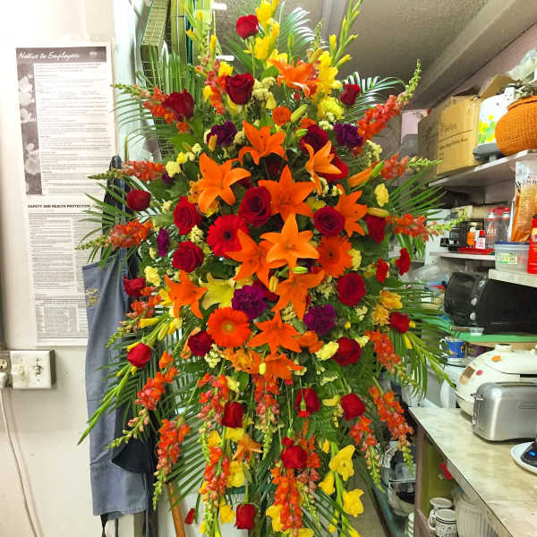 Tall standing floral spray with red, orange, and yellow flowers