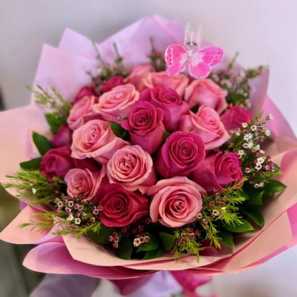 Bouquet of pink and red roses with a butterfly pick