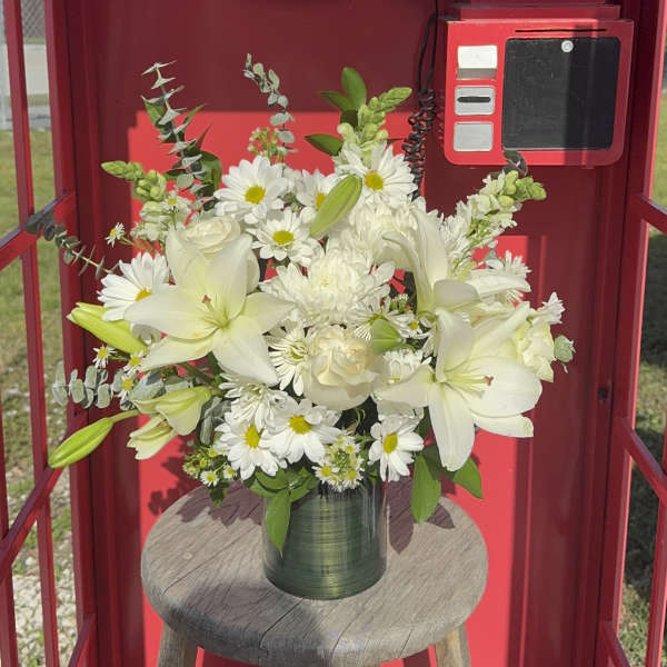 White lilies and daisies arranged in a green vase