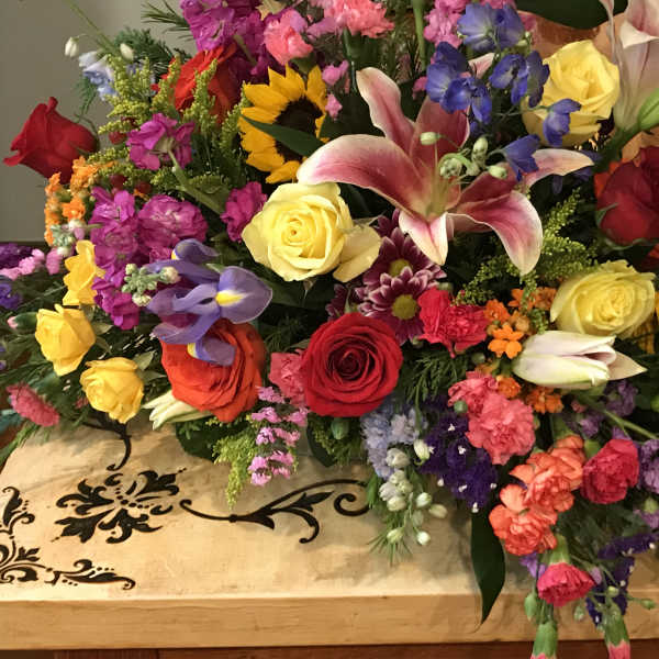 Colorful mixed flower arrangement with roses, lilies, and sunflowers on a table