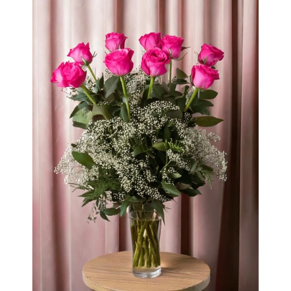 Pink roses in a clear glass vase with white baby's breath