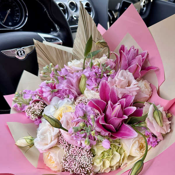 Pink and white bouquet with lilies and roses wrapped in pink paper