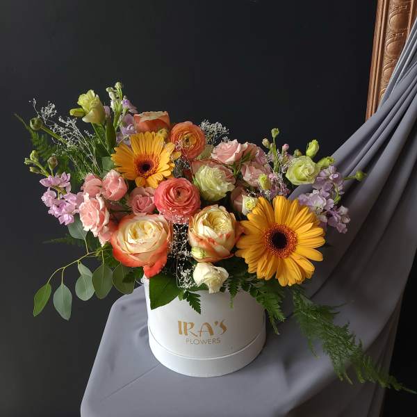 Mixed bouquet of roses, gerbera daisies, and pastel flowers in a white hat box