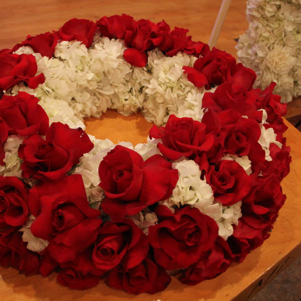 Red roses and white flowers arranged in a circular wreath