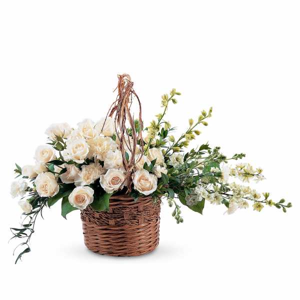 Cream roses and carnations in a wicker basket with trailing greenery