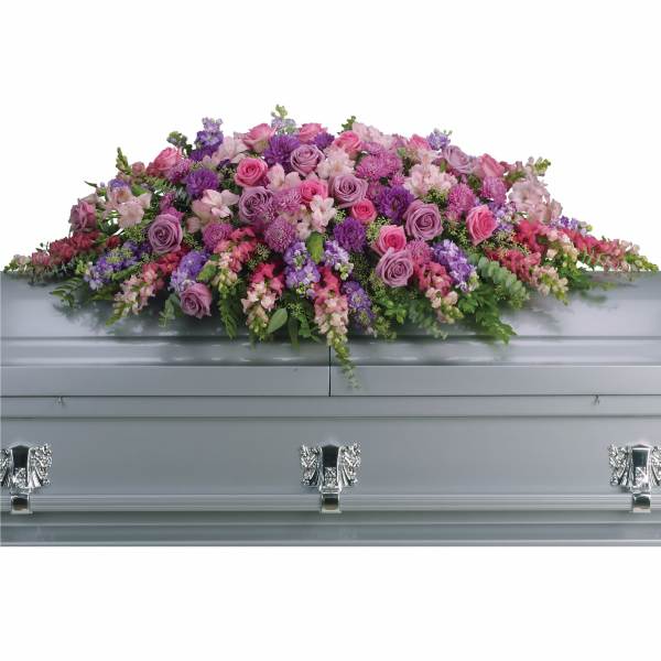 Pink and purple floral casket spray on a silver casket