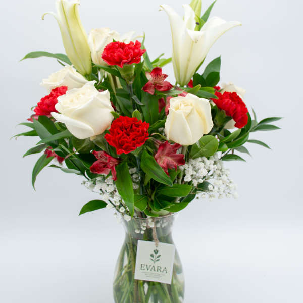 White lilies and red carnations in a glass vase