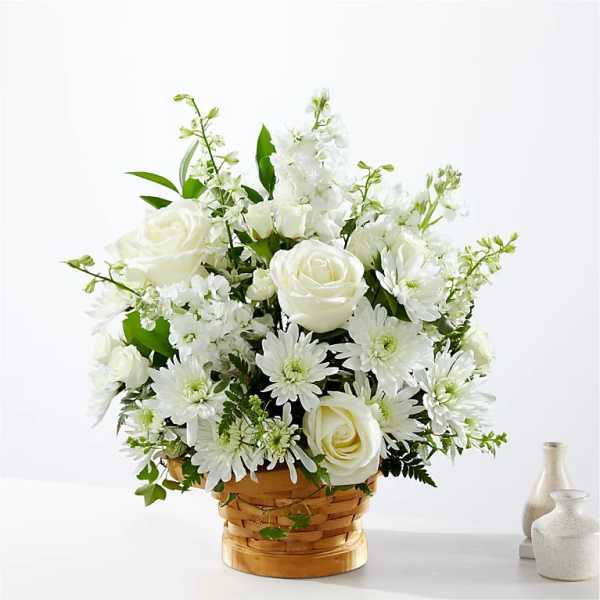 White roses and daisies arranged in a woven basket