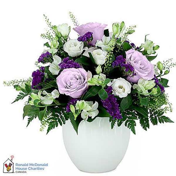 Lavender and white roses arranged in a white vase