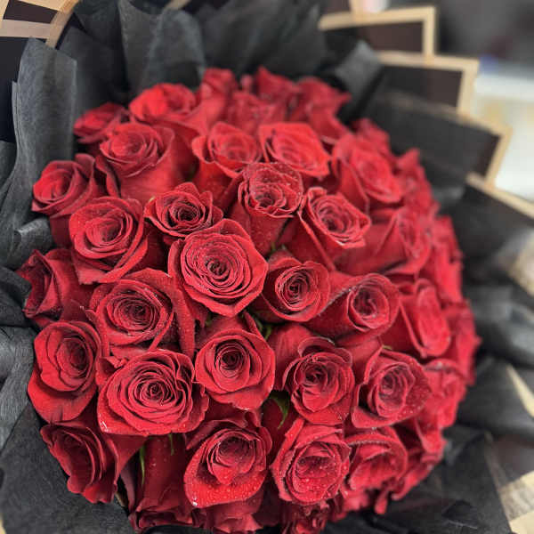 Bouquet of red roses wrapped in black paper