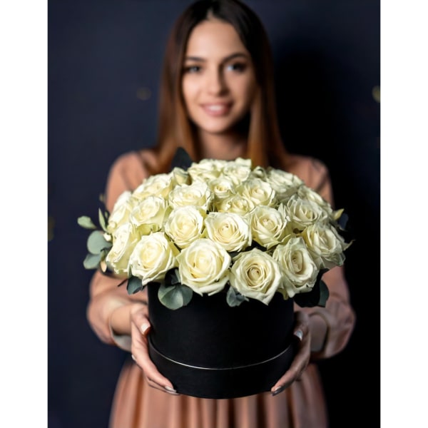Woman holding a black box filled with white roses