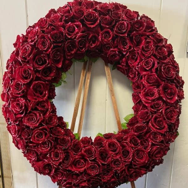 Large circular wreath of red roses on a wooden easel