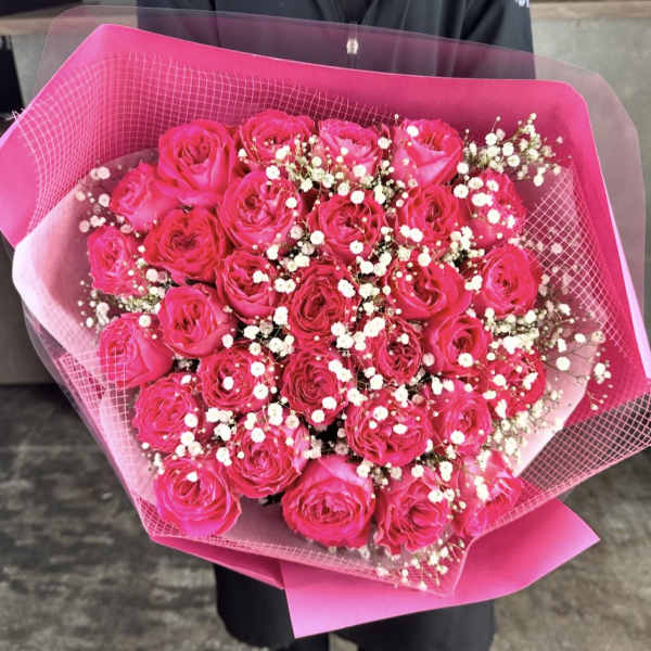Bouquet of hot pink roses with baby's breath wrapped in pink paper