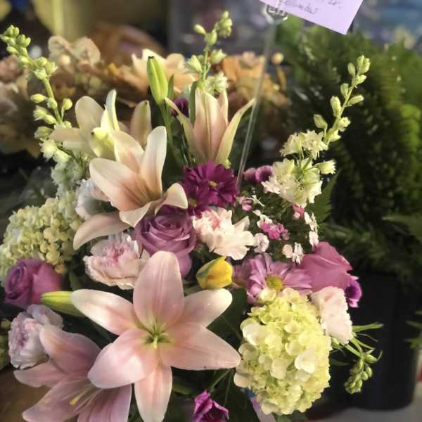 Pink lilies and purple flowers in a vase