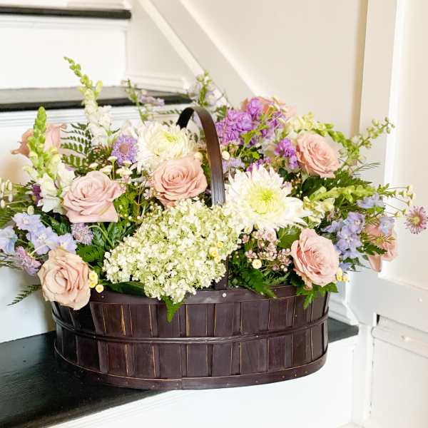 Basket of pastel roses, white blooms, and lavender flowers