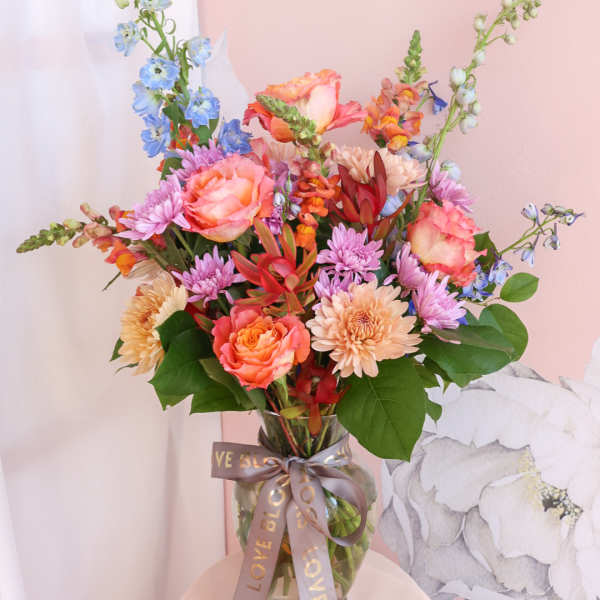 Colorful mixed bouquet in a glass vase with a ribbon