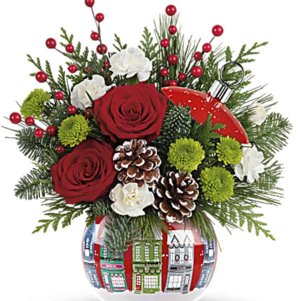 Holiday bouquet with red roses, white blooms, and pinecones in a decorated glass vase