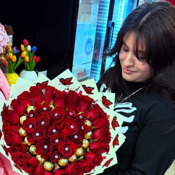 Heart-shaped bouquet of red roses with gold chocolates and butterfly wrap