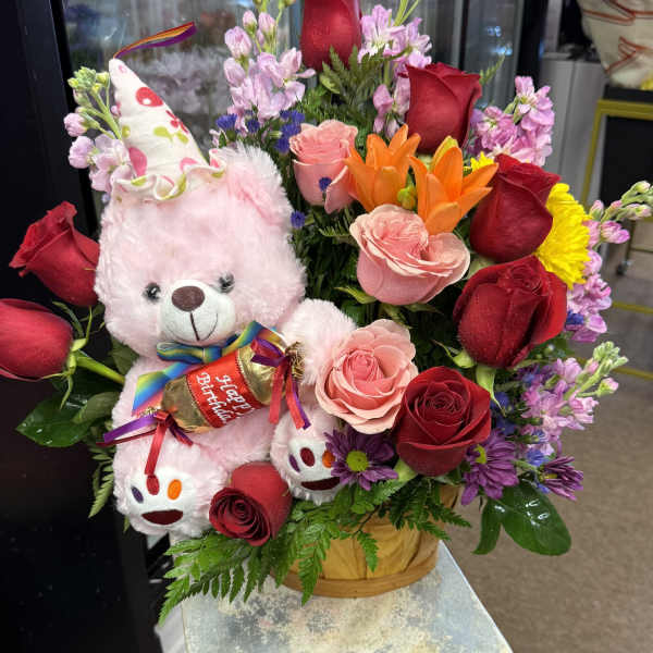 Bouquet with roses, lilies, and a pink teddy bear holding a birthday candy