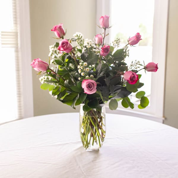 Pink roses arranged in a clear glass vase