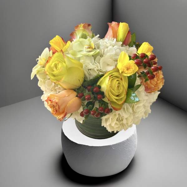 Bouquet of yellow and peach roses with white hydrangeas in a vase