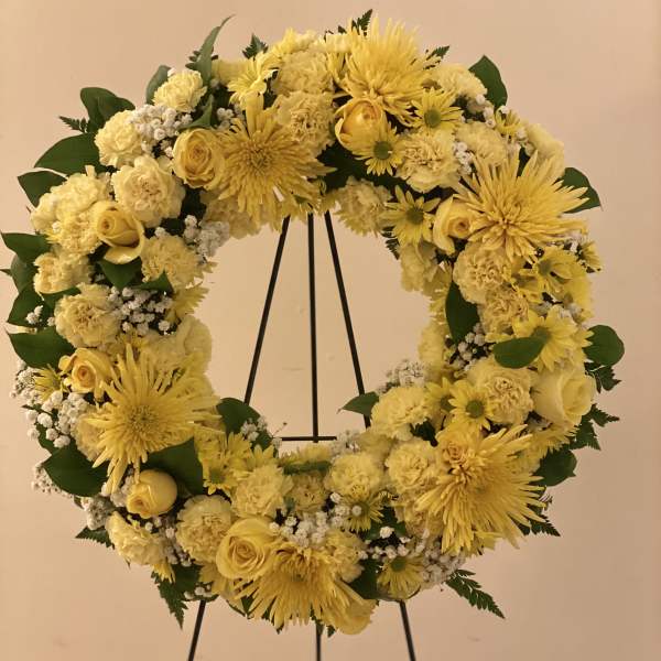 Yellow floral wreath on a black stand