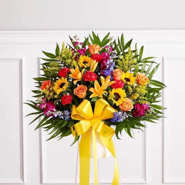 Colorful standing floral spray with a yellow ribbon bow