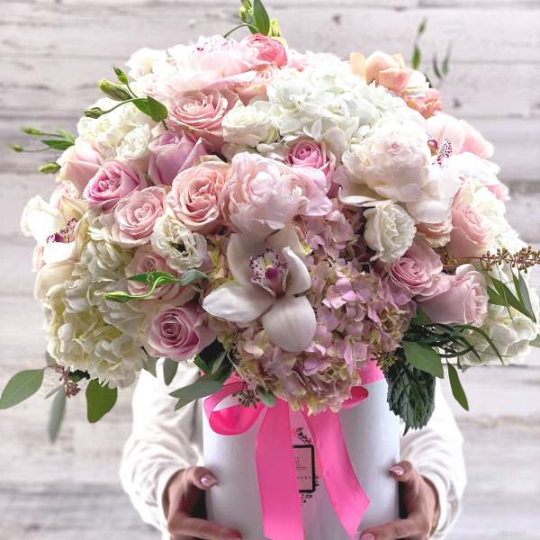 Large pastel bouquet in a white hat box with a pink ribbon