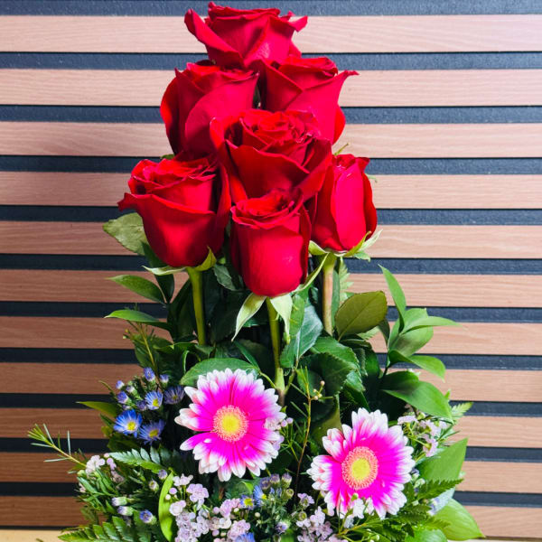 Red roses with pink daisy flowers in a mixed bouquet