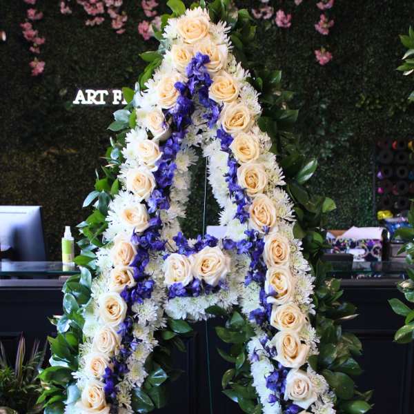 Large floral letter A on a stand with cream roses and purple flowers
