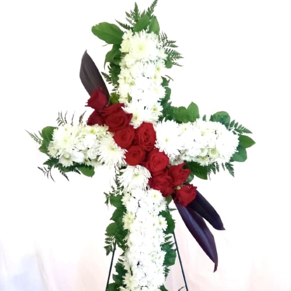 Cross-shaped floral tribute with red roses and white chrysanthemums