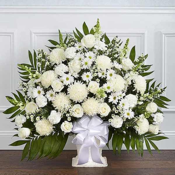 Large white floral arrangement in a white vase with a satin ribbon