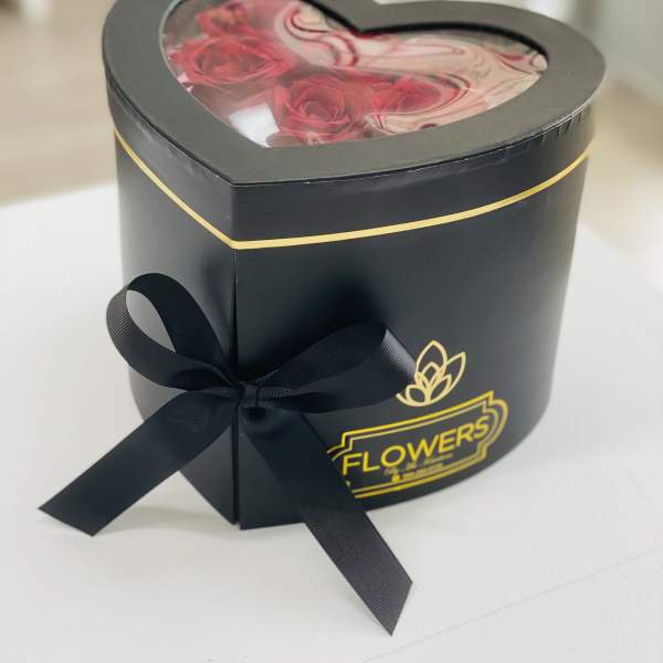Heart-shaped black gift box with red roses and a ribbon bow