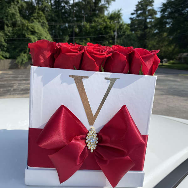 Red roses in a white gift box with a large red bow