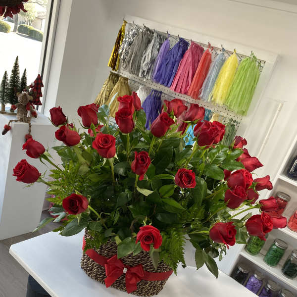 Basket arrangement of red roses with a red ribbon