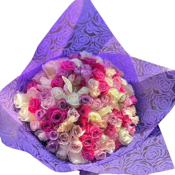 Bouquet of pink, white, and purple roses wrapped in purple paper