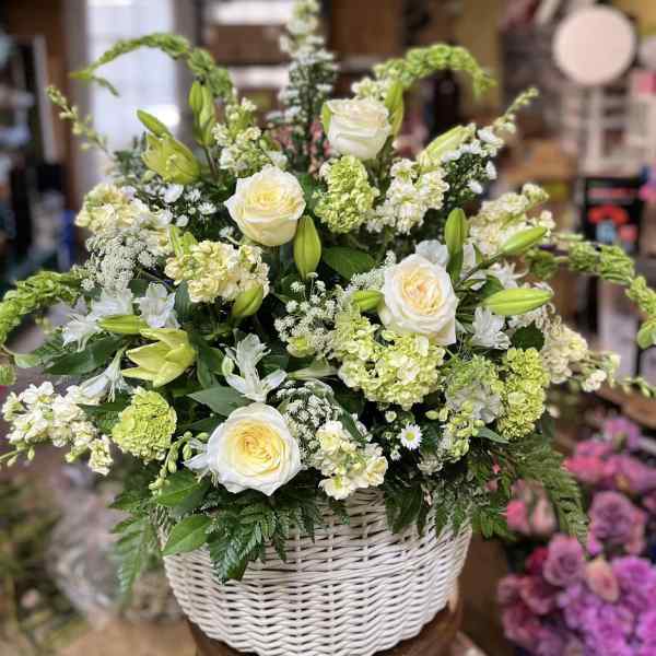 White roses and lilies in a white wicker basket