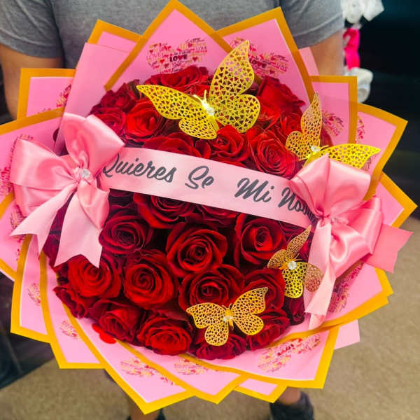 Bouquet of red roses with pink wrapping, bows, and butterfly decorations