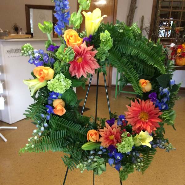 Colorful floral wreath on a black easel stand