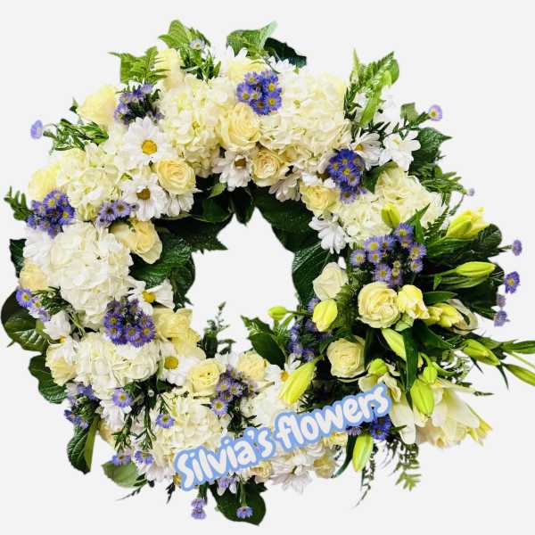 Circular floral wreath with white and pale yellow flowers and purple accents