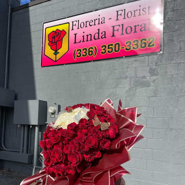 Large bouquet of red and white roses wrapped in burgundy paper