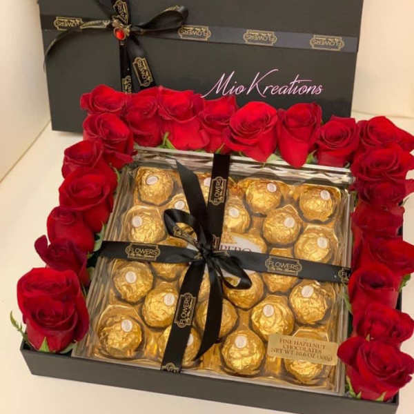 Red roses framing a gift box of Ferrero Rocher chocolates