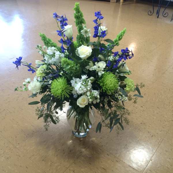 Blue and white floral arrangement in a clear glass vase