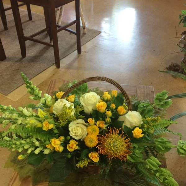 Basket arrangement of yellow and white flowers with greenery