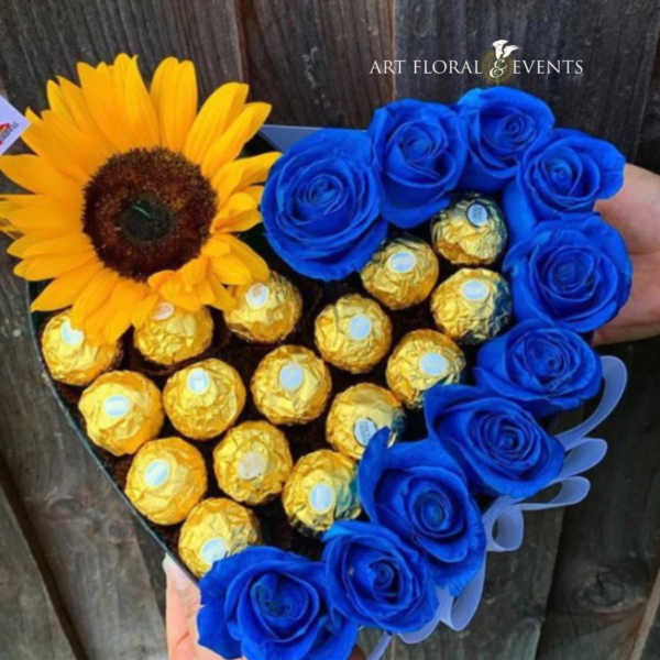 Heart-shaped bouquet with a sunflower, blue roses, and gold-wrapped chocolates