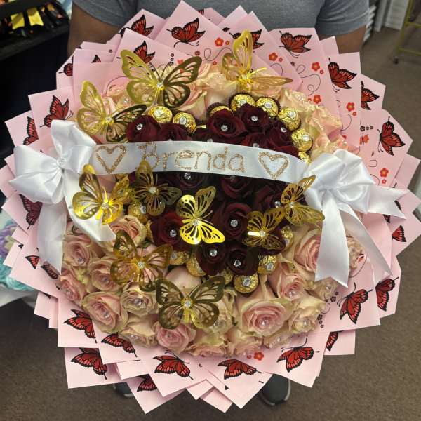 Bouquet of pink and burgundy roses with butterfly decorations and a white ribbon